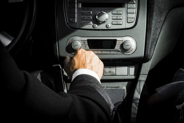 Driver adjusting controls at the dashboard