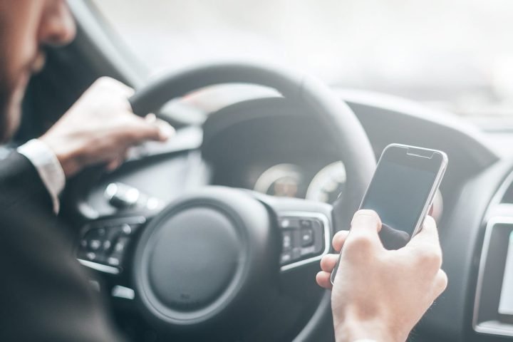 Driver holding a mobile phone at the wheel