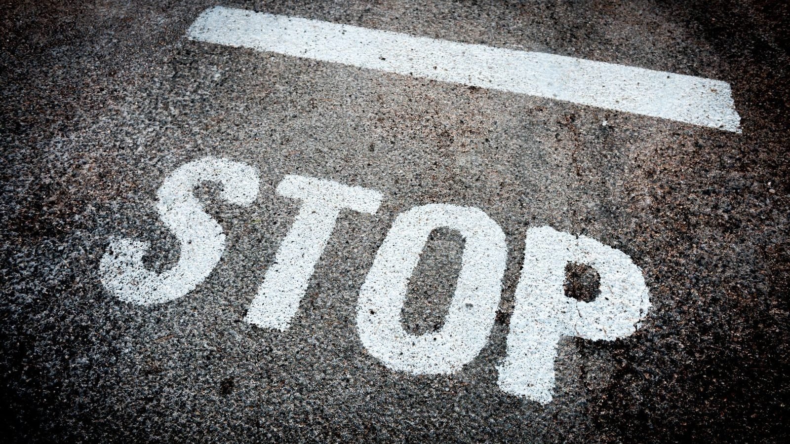 STOP marking painted on a road surface