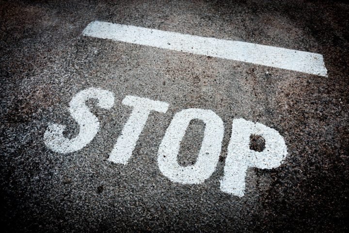 STOP marking painted on a road surface